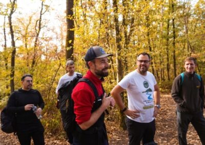 Vier Männer mit Sportrucksäcken wandern durch den Wald