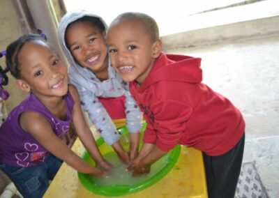 Drei Kinder waschen ihre Hände