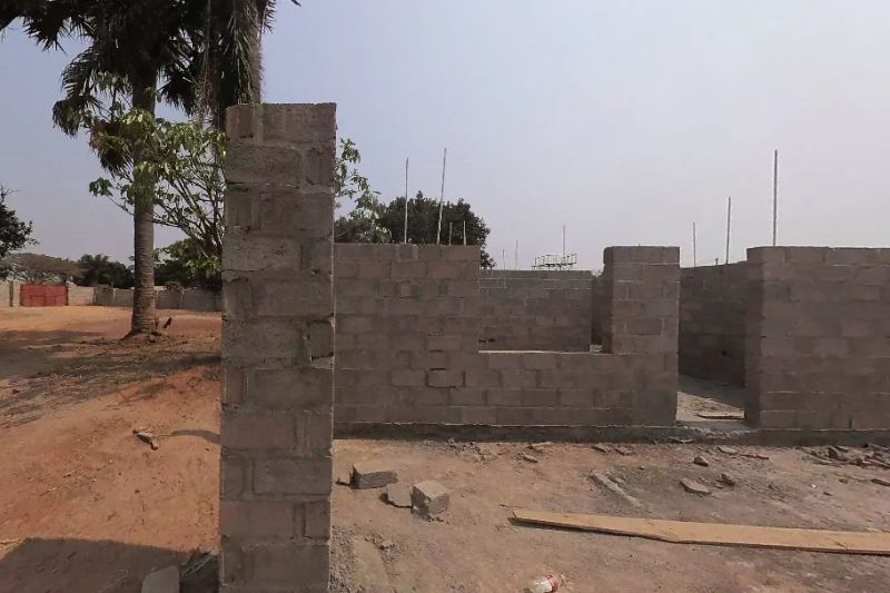 Rohbau eines Schulgebäudes in Kazembe Sambia Die ersten Mauern aus Betonsteinen stehen während die Bauarbeiten noch andauern